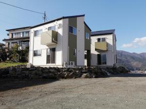 富士河口湖的住宿－貸別荘 ウサギの郷，前面有石墙的房子