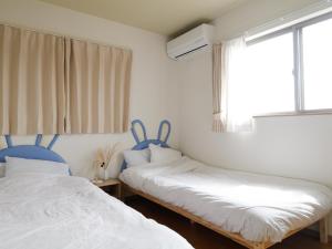 富士河口湖的住宿－貸別荘 ウサギの郷，一间卧室设有两张床和窗户。
