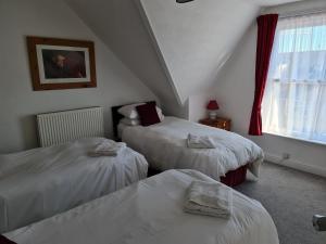 Marden guest house في ويماوث: غرفة نوم بسريرين ونافذة