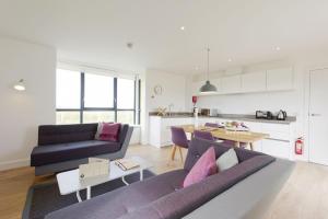 a living room with a couch and a table at Buckie - 2 Bed Luxury Apartment in Wick +9 photos
