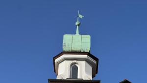 une vue sur la flèche d'un bâtiment contre un ciel bleu dans l'établissement Laura, à Äschach