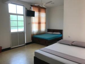 卡塔拉伽馬的住宿－Hotel Ganthera Kataragama，一间卧室设有两张床和窗户。