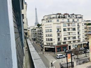 Blick auf eine Straße mit einem Gebäude und den Eiffelturm in der Unterkunft St Dominique - Vue Tour Eiffel in Paris