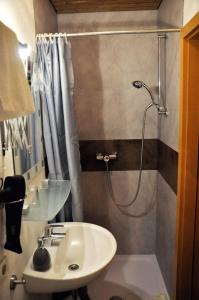 een badkamer met een wastafel en een douche met een douche bij Pension Hirsch in Lechbruck