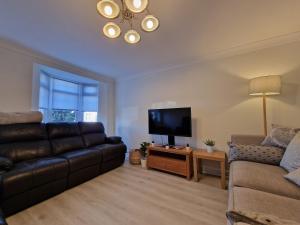 een woonkamer met een bank en een flatscreen-tv bij DYSA Bentinck House in Blackpool