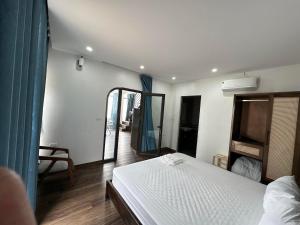 a bedroom with a white bed and a mirror at Wonderland Homestay - Venuestay in Vĩnh Phúc