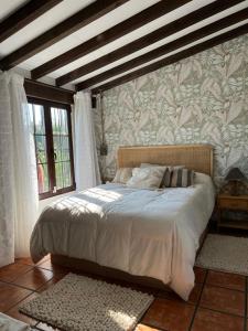 a bedroom with a large bed with a wall at Posada La Fontana in Santillana del Mar