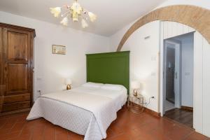 a bedroom with a bed with a green headboard at Acquamarina in Spello