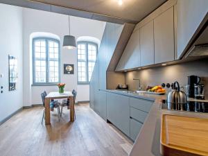 a kitchen with a table and a sink and a counter at Kultur Gut Hasselburg in Altenkrempe