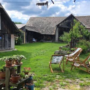 a yard with two chairs and a building at Village farm house Nazri 