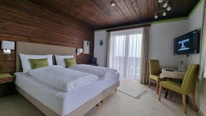 1 dormitorio con 1 cama grande, escritorio y TV en Pension Schöne Aussicht en Kuchl