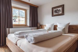 2 Betten in einem Hotelzimmer mit Fenster in der Unterkunft Riatschhof in Nauders