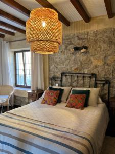 a bedroom with a bed with a stone wall at Posada La Fontana in Santillana del Mar