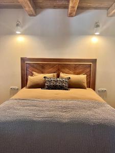 a large bed with a wooden headboard and pillows at Les Demeures de Piana in Piana