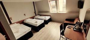 um pequeno quarto com 2 camas e uma janela em Hotel Kliper em Władysławowo