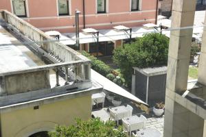 un balcone con vista su un edificio con tavoli e sedie di HOTEL DUCA D'AOSTA a Mogliano Veneto