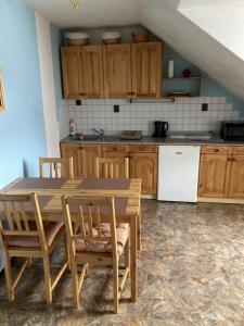 a kitchen with wooden cabinets and a table and chairs at Apartmán Na Ostrově Beroun in Beroun