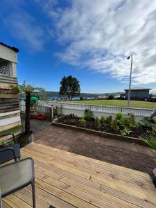 a wooden deck with a bench and a fence at Raglan Seaview Cabin in Raglan