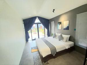 a bedroom with a large bed and a large window at Kampot Tropical Village in Kampot