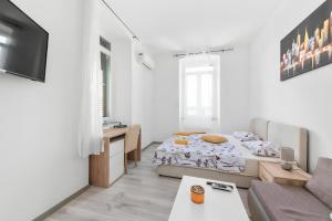 a white room with a bed and a couch at Market & Art square place in Rijeka