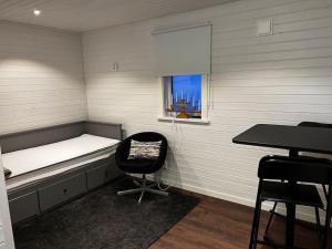 a room with a bed and a chair and a window at Stuga i Transtrand in Transtrand