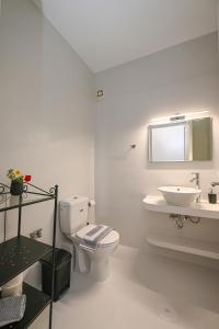 Baño blanco con aseo y lavamanos en Santamare Apartment, en Agios Sostis