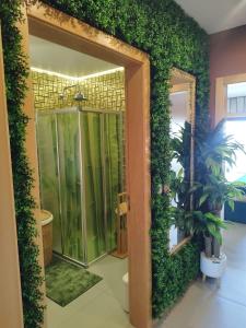 a bathroom with a green wall with a walk in shower at Wherry Green Guest House (PRAIA DA BARRA)❤️ in Praia da Barra