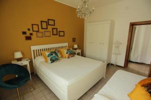 アルゲーロにあるLa Terrazza - Residenze MariCharmeのベッドルーム(白いベッド1台、青い椅子付)
