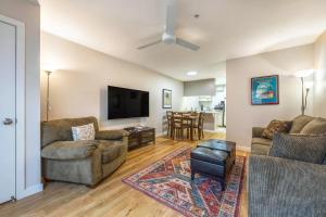 a living room with two couches and a flat screen tv at 15 Lodge with Hood River Bridge View in Hood River