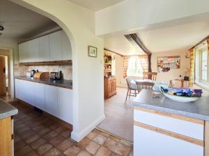 a kitchen with white cabinets and a dining room at The Mansion Cottage in Tetford