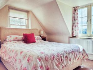 a bedroom with a bed with a red pillow on it at The Mansion Cottage in Tetford