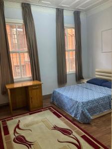 a bedroom with a bed and a table and windows at Üsküdar Villa in a Great Location in Istanbul