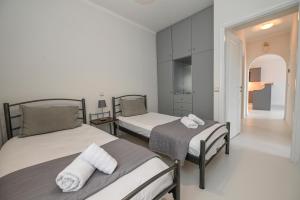 アギオス・ソスティスにあるSantamare Apartmentのベッドルーム1室(ベッド2台、タオル付)