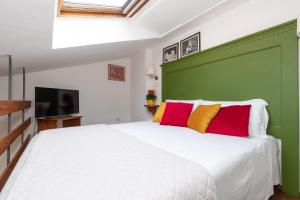 una camera da letto con un letto bianco con cuscini rossi e gialli di Corallo a Spello