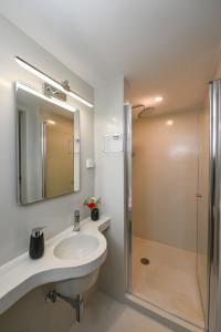 a bathroom with a sink and a shower at Santamare Apartment in Agios Sostis