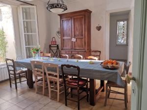 a dining room with a blue table and chairs at La Taniere 16 couchages in Vergèze