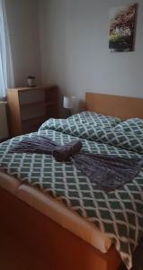 a bed with a blue and white blanket on it at Privat Bartky in Vrbov