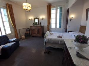 Un dormitorio con una cama, un sofá y un espejo. en La Taniere 16 couchages, en Vergèze