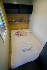 - un petit lit dans une petite chambre avec des serviettes dans l'établissement Mobile house Tina 31, à Metlika