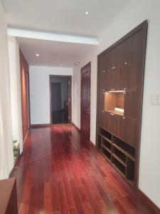 a hallway with wood flooring and a large wooden cabinet at Davidduc's apartment 23 Tay Ho in Hanoi