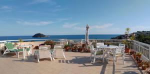 a patio with tables and chairs and the ocean at VentoVerde B&B in Albenga