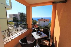 a balcony with a table and chairs and a large window at Residence Gordana 2 in Selce