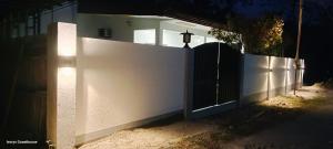a white fence with a gate in front of a house at Ivorys Guesthouse in Panglao +4 photos