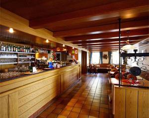 a bar in a restaurant with a counter at Alpin Hotel & Restaurant Frara in Selva di Val Gardena