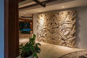 a wall with a wooden carving of trees on it at Villa Mimpi Nyata in Canggu