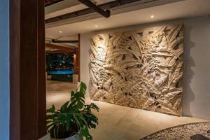 Una pared con una talla de madera de árboles en ella en Villa Mimpi Nyata, en Canggu 57 fotos más