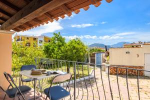 a patio with a table and chairs on a balcony at 3 - Casa con giardino Lotzorai - Sa Crai Apartments Sardinian Experience in Lotzorai