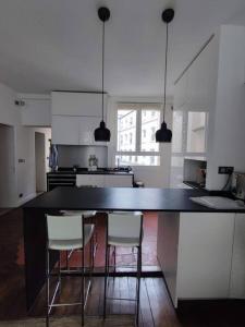 kuchnia z czarnym blatem i krzesłami w obiekcie Air conditioning Paris central stylish apartment w Paryżu