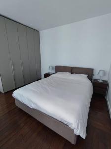 sypialnia z łóżkiem z białymi prześcieradłami i drewnianą podłogą w obiekcie Air conditioning Paris central stylish apartment w Paryżu