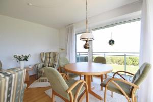 uma sala de jantar com uma mesa e cadeiras e uma janela em Ferienwohnung 2 im Strand Palais em Cuxhaven